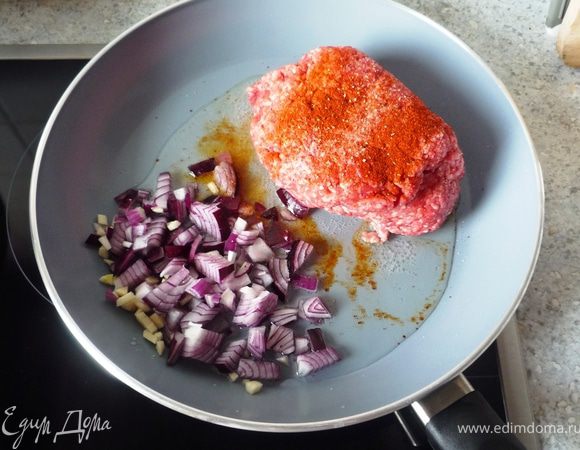 Поставить отвариваться спагетти. Тем временем на оливковом масле обжарить мелко порезанный лук, чеснок и фарш, предварительно приправленный солью, перцем и парикой, до рассыпчатого состояния.