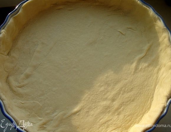 Слоёное тесто раскатать по размеру формы(26 см)с бортиком.Наколоть вилкой и выпекать в разогретой до 180*С духовке 10-15 минут.