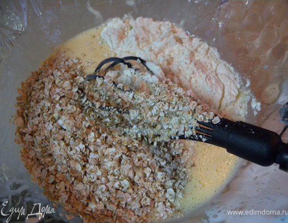 Просеять муку с разрыхлителем и крахмалом. Добавить хлопья. 