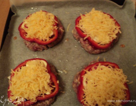 На котлету, смазанную кетчупом, выложить немного лука, кружочки помидор, смазывая слегка каждый слой майонезом. Выложить колечко перца, слегка вдавив в котлету, и посыпать все сыром.