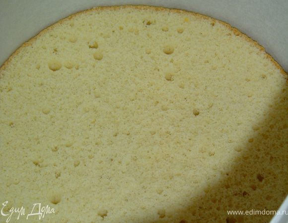 В разъемную форму кладем один корж, а по периметру устанавливаем бортик из пергаментной бумаги.