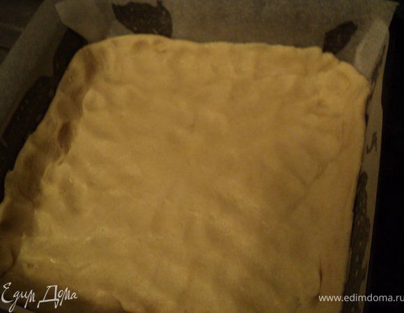 Дно и бока формы  застилаем бумагой для выпечки, смазываем растительным маслом. Выкладываем раскачанное тесто и формируем небольшие бортики.