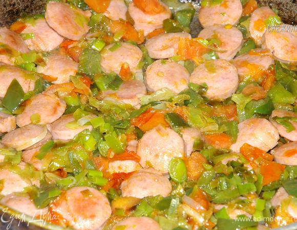 Вернемся к сковороде. Когда сосиски хорошо подрумянились, добавляем помидоры, даем им пустить сок, и тушим все пару минут.