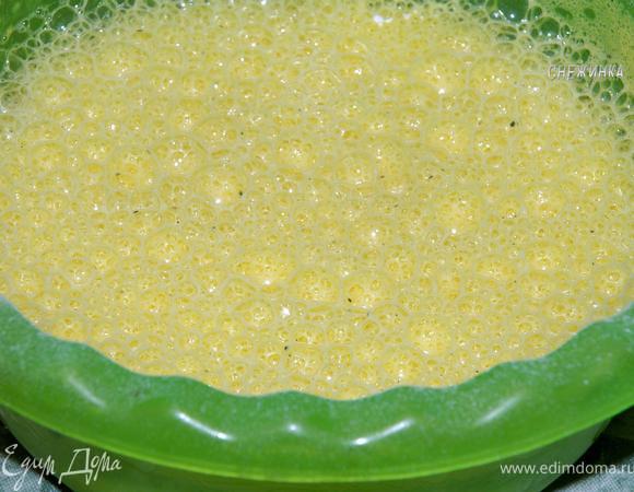 Теперь к яично-молочной массе добавляем муку, смешанную с содой. Еще раз слегка взбиваем. Должна получится пузырчатая жидкость.