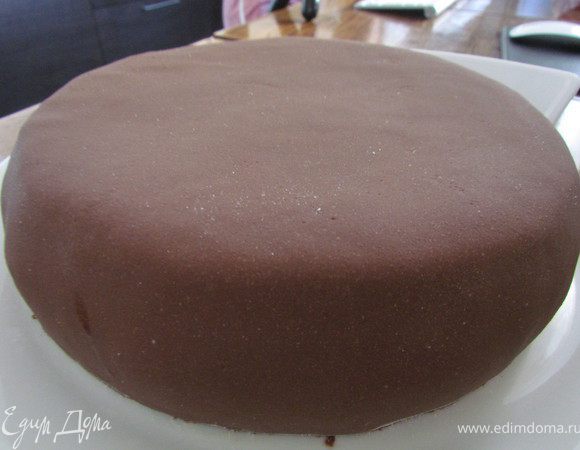 Утречком я тортик еще раз выровняла. Сделала шоколадную мастику (растопила 100 гр. маршмелоу с плиткой шоколада, 1 ст.л. сл. масла и 1 ст.л. молока, всыпала сахарную пудру и замесила до консистенции пластилина), раскатала полученную мастику и покрыла ей торт. 