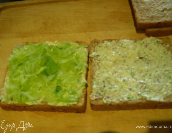 Собираем наш сэндвич. На хлеб намазываем заправку (2 кусочка или все 4, по желанию, у меня 4), затем выкладываем огурец, накрываем вторым кусочком сверху. 
