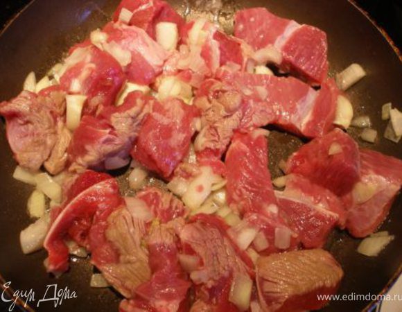 Говядину нарезать кубиками, обвалять в сахаре. Поджарить на оливковом масле с луком до полуготовности. 