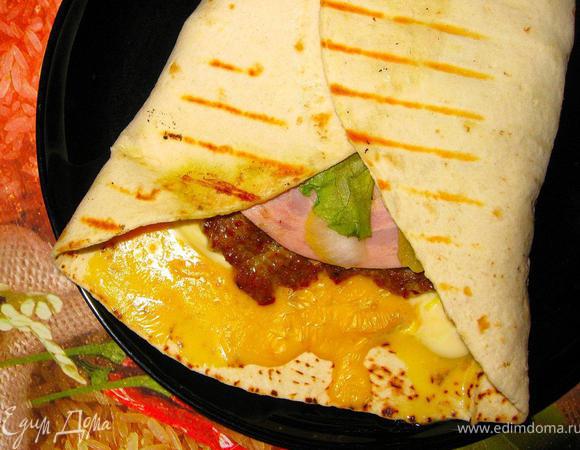 Свернем наши роллы конвертиком и отправим на разогретый гриль. Прогреем с двух сторон 2-3 минуты. Фокачча станет хрустящей, сыр внутри расплавится и все содержимое пропитается соусом и мясным соком. Выкладываем роллы на тарелки и наслаждаемся прекрасным вкусом нашего домашнего фастфуда. Вы можете сделать такие роллы с куриным филе, бургерами из индейки, рыбными биточками и т.д., используйте те продукты, которые вы любите. Приятного аппетита!