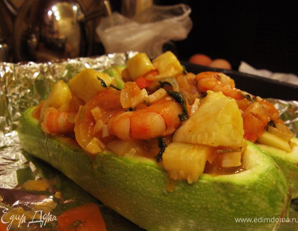 Небольшой противень застелить фольгой и смазать ее сливочным маслом. Кабачковые лодочки положить на фольгу, посолить изнутри и посыпать половиной сухарей. Начинить кабачки креветками с овощами, сверху посыпать начинку оставшимися сухарями.