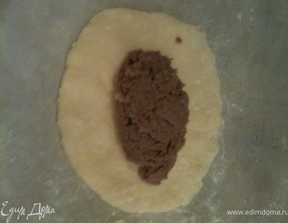 Отрезать от колбаски кусочек и сделать из него блинчик. На блинчик положить начинку (в пирожках на фото мясной фарш из оленины).