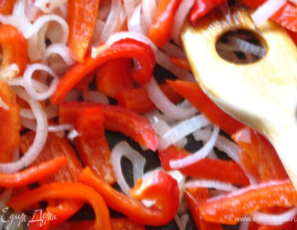 В сковороду с разогретым оливковым маслом  кладем лук и обжариваем на среднем огне в течении нескольких минут, пока он не станет прозрачным. Добавляем перец. Закрываем крышкой и жарим, периодически помешивая до полуготовности. Это примерно 7 минут