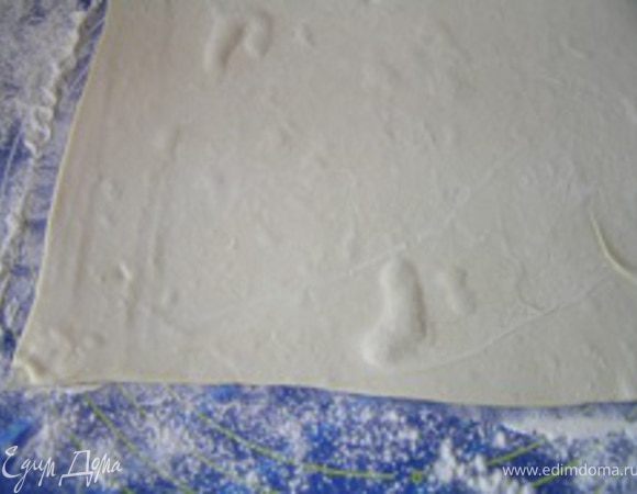 Немного раскатать тесто, посыпав поверхность мукой.