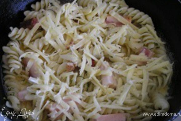 В миске немного взбить яйца, вылить в сковородку на макароны, сверху посыпать тертым сыром.