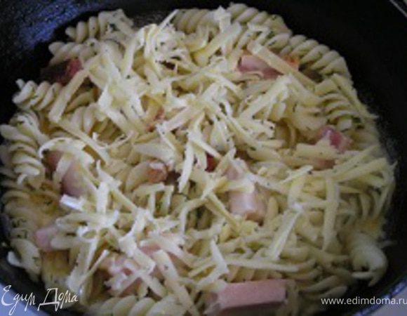 В миске немного взбить яйца, вылить в сковородку на макароны, сверху посыпать тертым сыром.