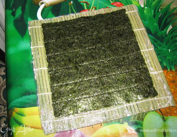 Циновку я предпочитаю обматывать пищевой пленкой и совсем немного смазывать маслицем(чтобы ничего вдруг не прилипло).

На циновку положим целый лист нори(для следующих роллов я использовала половинки листа, так ролл получается меньше и его удобнее кушать).