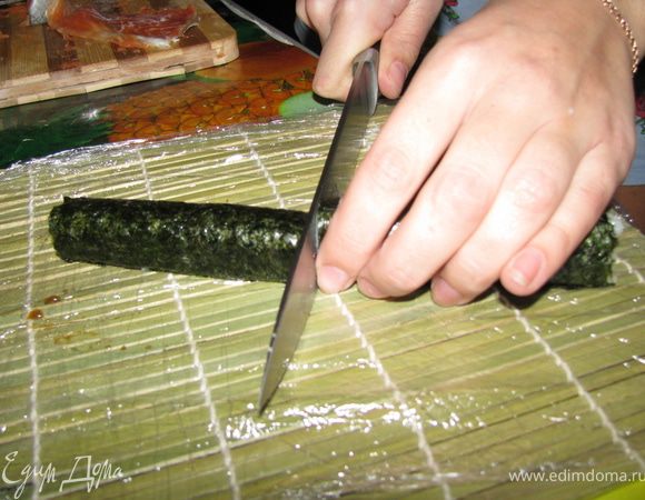 Оставшуюся полоску нори немного смачиваем и склеиваем ролл. После чего придаем ему желаемую форму и смоченным ножом разрезаем пополам.