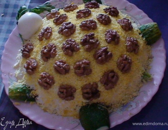 Окорочка отварить до готовности. Остудить. Мелко нарезать. Лук мелко нашинковать.
 Залить его кипятком, и оставить на 10 минут. Затем воду слить, лук промыть в холодной воде (это делается для того, чтобы лук не горчил). Отделить белки от желтков. Белки желтки натереть на мелкой терке по отдельности. Яблоко натереть на мелкой терке.
 Сыр натереть на мелкой терке. На плоское блюдо выложить белки в форме овала, немного посолить, смазать майонезом.
 На белки выложить филе, разровнять, смазать майонезом. На филе выложить лук. На лук выложить яблоко, смазать майонезом.
 Немножко тертого сыра отложить для украшения верха, остальной сыр выложить на яблоко, смазать майонезом.
 На сыр выложить желтки, смазать майонезом. Начинаем украшать салат сыр тертый, орехи, 1 яйцо немного подрезать низ чтобы стало на блюдо и сделать ножки и хвостик из огурцов можно как и из свежих так и кислых или маринованных. и можно зеленью украсить. Такой салат ушел за 10 минут у моих друзей очень нежный вкус попробуйте!! 