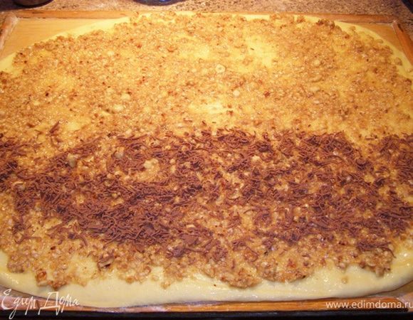 Раскатаем тесто в тонкий пласт, смажем его растопленным сливочным маслом, сверху распределим ореховую смесь. У меня было пол шоколадки, я ее натерла на терке и распределила на половину теста