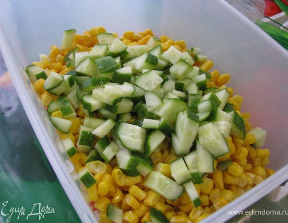 Мелко нарезаем огурцы и добавляем их к кукурузе и крабовым палочкам.