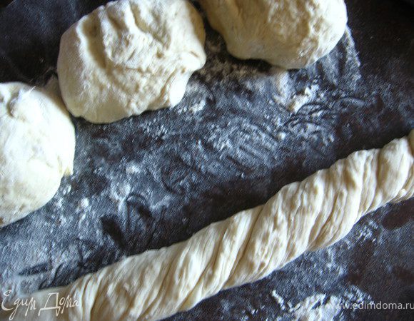 Стол присыпаем мукой. Выкладываем тесто и делим на 4 части. Каждую часть формируем в балет и скручиваем в жгут. 