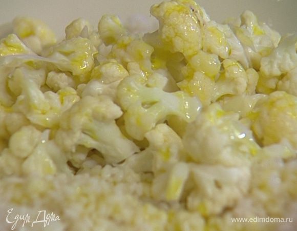 Выложить рис на большое блюдо, полить половиной лимонного сока, сверху выложить цветную капусту, сбрызнуть оливковым маслом.