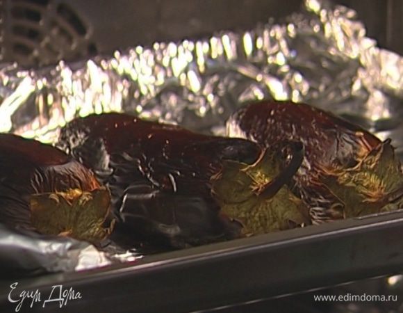 Баклажаны часто наколоть вилкой, уложить на выстеленный фольгой противень и запекать под разогретым грилем 25–30 минут, периодически переворачивая.