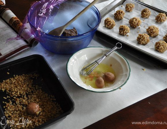  Белки взболтать,отложить.Орехи порубленные выложить в удобную посуду.
Достать тесто,сделать небольшие шарики,окунать вначале в белки, а затем в орехи.Со всех сторон обкатать.