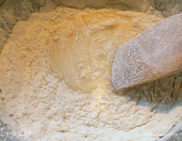Постепенно добавить разрыхлитель и муку, замесить мягкое тесто. Оно должно получиться влажным, липким, тяжелым, но не крутым, с ложки стекать не должно, расползаться на противене тоже. 