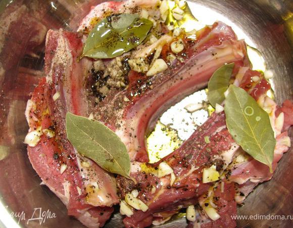Помыть мясо, обсушить бумажным полотенцем, поперчить, приправить прованскими травами, розмарином, лаврушкой, мелко нарезаным чесноком, полить оливковым маслом. 