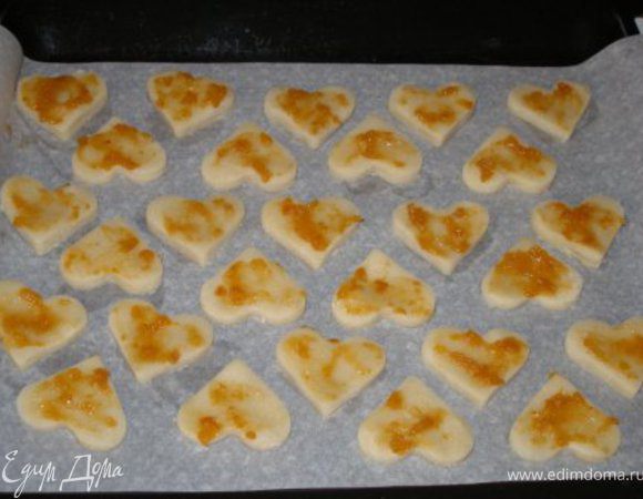 Вырезать из теста фигурки и выкладывать на противень, застеленный пергаментом. Можно делать печенье более объемным, а в середину класть начинку. Конкретно в этом случае я смазывала его абрикосовым джемом (но можно и без него обойтись). Выпекать при 180С до тех пор, когда печенье приобретет приятно золотистый цвет. 
