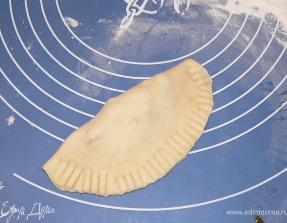 Выкладывать ложкой начинку на середину каждого диска, смочить края водой и залепить . Пройтись по краю вилкой.
