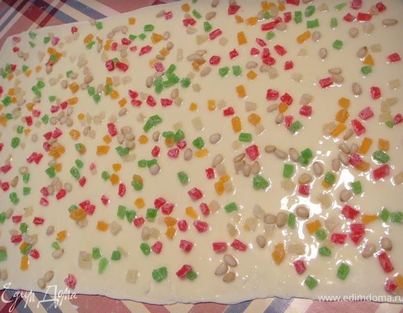 Раскатать из теста прямоугольник. Смазать сгущеным молоком, посыпать мелко порезанными цукатами и кедровыми орешками.