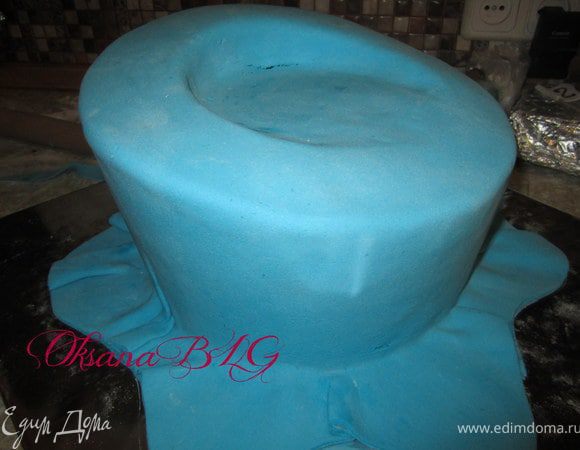 Покрыть торт мастикой. Первый ярус синий, низ можно  немного оставить с волной.