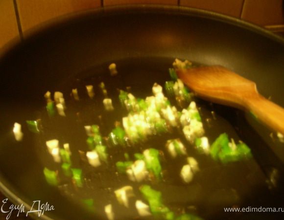 Разогреваем масло в сковороде, добавляем мелко порезанный чеснок, чили и кумин, обжариваем пару минут на довольно сильном огне.