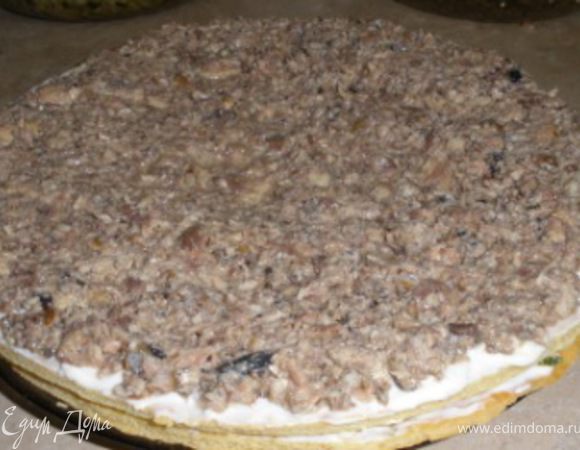 Укладывается пирог следующими слоями: 1-корж, смазывается плотно майонезом и высыпается половина нарезанных яиц с зеленым луком, все равномерно распределяется по коржу.
2-сверху ложится следующий корж, смазывается плотно майонезом и выкладывается равномерно вся рыбная начинка.