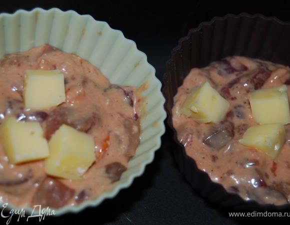 Выкладываем тесто в формочки. Если не силиконовые, смажьте сливочным маслом. По желанию можно добавить в серединку несколько кусочков сыра.