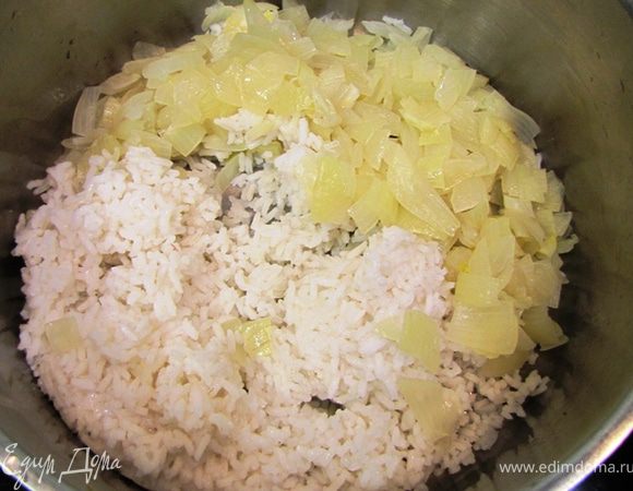 Положите лук к рису и поставьте на медленный огонь. Я переложил в большую кастрюлю и долил пару столовых ложек воды.
Перемешивайте и тушите лук с рисом в течение 10 минут.