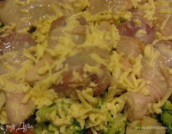 В форму для запекания слоями выкладываем лук, морковь, цветную капусту, горошек. Поверх овощей разложить куриные ножки и залить все соусом.