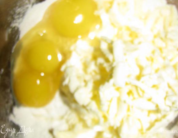 Сливочное масло трем на крупной терке, смешиваем с солью, мукой, яйцами. Заворачиваем тесто в пищевую пленку, отправляем в холодильник на 30 минут.