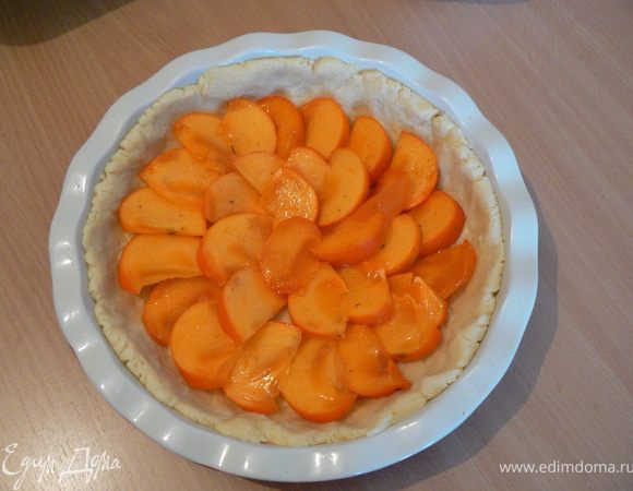 Замешиваем тесто,выкладываем его в форму,делаем бортики.
Сверху укладываем хурму