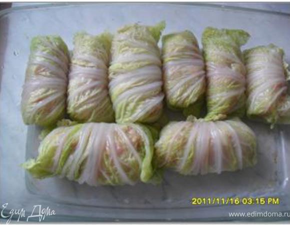 В капустные листья выложить фарш и завернуть их.