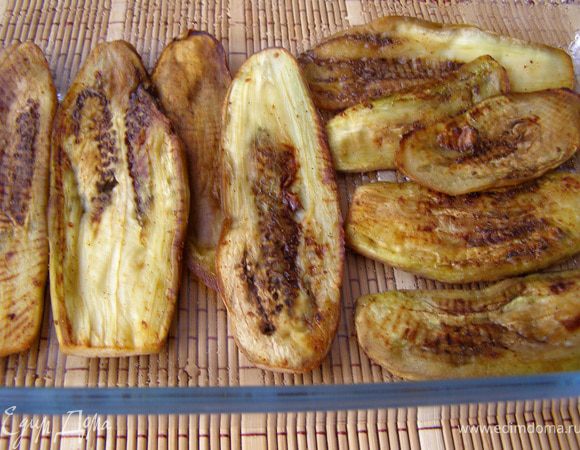 Цветную капусту разобрать на соцветия, отварить в подсоленной кипящей воде со специями 5 мин.
Баклажаны очистить от кожицы, порезать вдоль пластинами толщиной 0,5-0,7 см, натереть солью, оставить на 20 мин. Отжать бумажными полотенцами влагу, смазать маслом с 2-х сторон, обжарить на раскалённой сухой сковороде по 5-7 мин с каждой стороны до румяной корочки. Выложить слой баклажанов на дно смазанной маслом формы. (У меня была стеклянная форма 20х30 см)