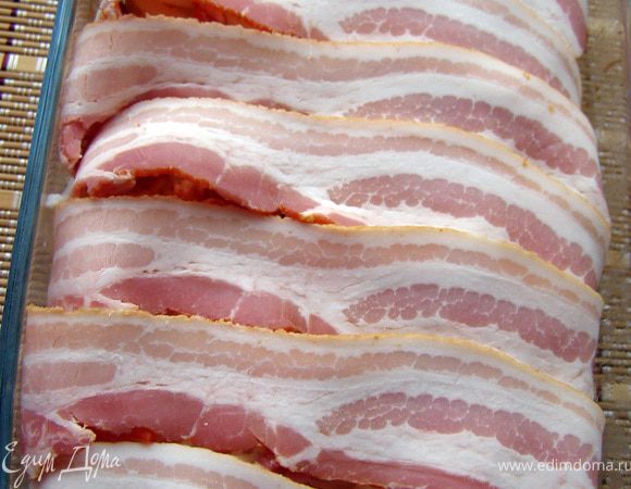 А теперь то, что даст сырым овощам замечательную сочность, а запеканке в целом - хрустящую корочку, аромат и красоту. Я говорю о беконе. Выложим его полосками поперёк формы. При запекании бекон будет немного сжиматься и образует нарядную волнистую поверхность. Красота!!!