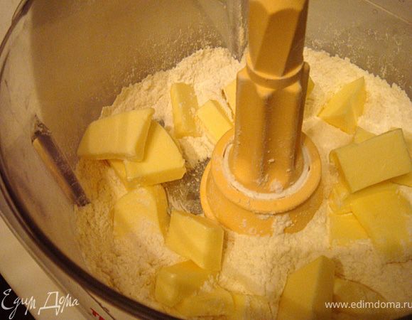 Сделаем песочную основу для нашего тарта: масло сливочное (холодное) порезать мелким кубиком и убрать снова в холодильник. Муку, сахарную пудру и соль соединить в чаше комбайна (насадка- нож) и перебить в течение минуты, двух. Добавить разом холодные кусочки масла и выбить смесь в комбайне, пока тесто не соберется в единый цельный комок- станет однородным . Форму для выпечки хорошо смазать маслом (не жалейте, чтоб тарт потом легко достать).
