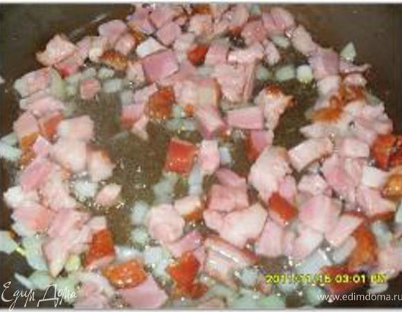 На сковороде разогреть растительное масло и выложить чеснок. Когда чеснок обжарится, вынуть его из сковороды. Бекон нарезать кубиками и обжарить на чесночном масле. Лук мелко нарезать и добавить в сковороду.