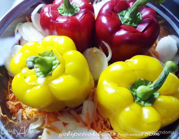 Оставшуюся луковицу нарезать крупными кольцами, морковь натереть на крупной терке, выложить овощи в кастрюлю к перцам.