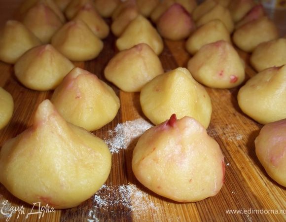 Приступаем к приготовлению полуфабриката: для этого отщипываем от теста кусочек веилиной как небольшой грецкий орех, делаем из него шарик, затем  ладони делаем из него кругленькую лепешечку, в середину выкладываем вишенку, защинываем края, придавая форму труфелей. 