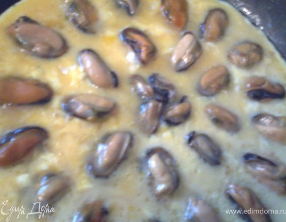 Выливаем омлет на чеснок и выкладываем мидии. Солить не надо, т.к.они отдадут соль яйцам достаточно.