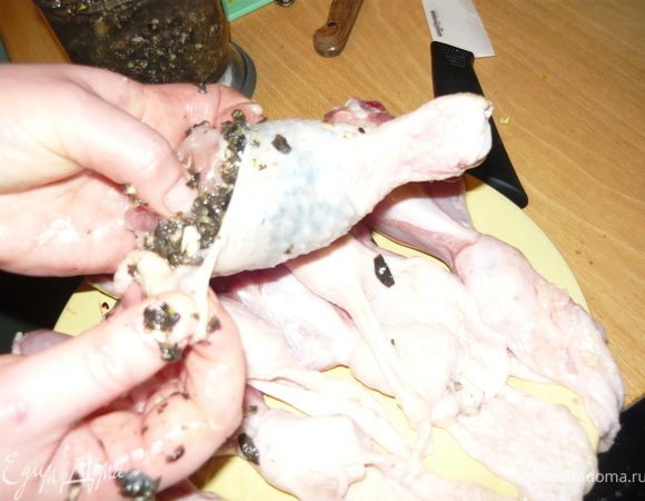 Каждую голяшку обмазать получившейся маслинно-чесночной смесью и спустить на место кожу, прижав таким образом смесь к мясу. 