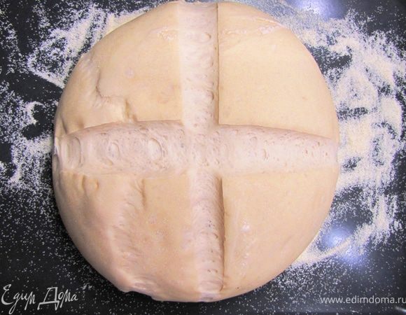 В это время нагрейте духовку до 230 градусов. Поставьте на дно духовки емкость с водой, чтобы духовка насытилась парами. Вода должна закипеть или по крайней мере от нее должен идти пар.
Сделайте надрезы крест-накрест лезвием, чтобы хлеб не растрескался в процессе запекания.